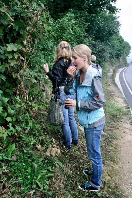 a woman holding onto another woman near some plants