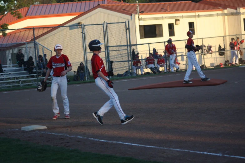 young baseball players run on the field during a game