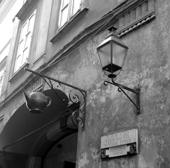 a street lamp hangs on the side of a building