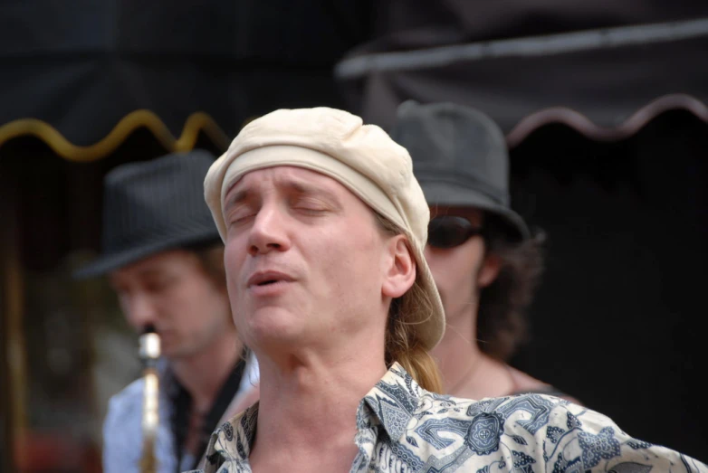 a male with a hat and other males are wearing hats