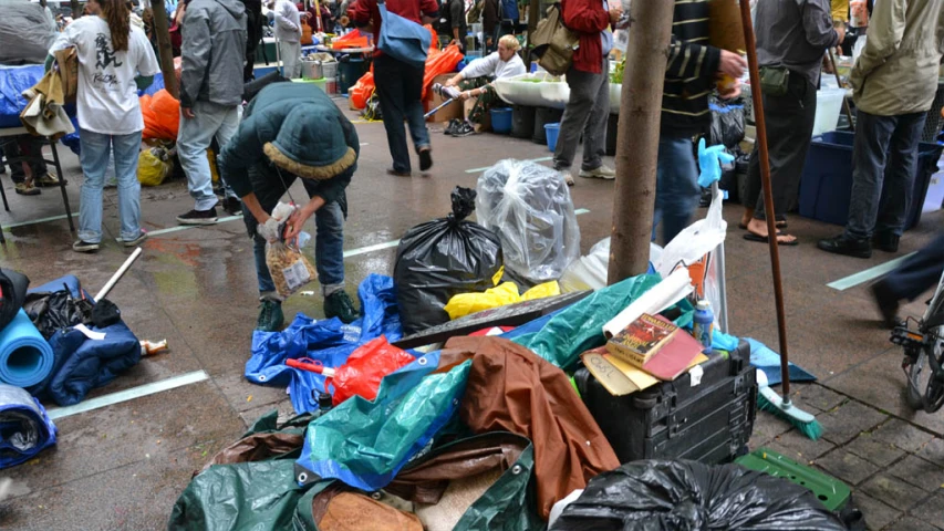 people walk through an open market with various items on display