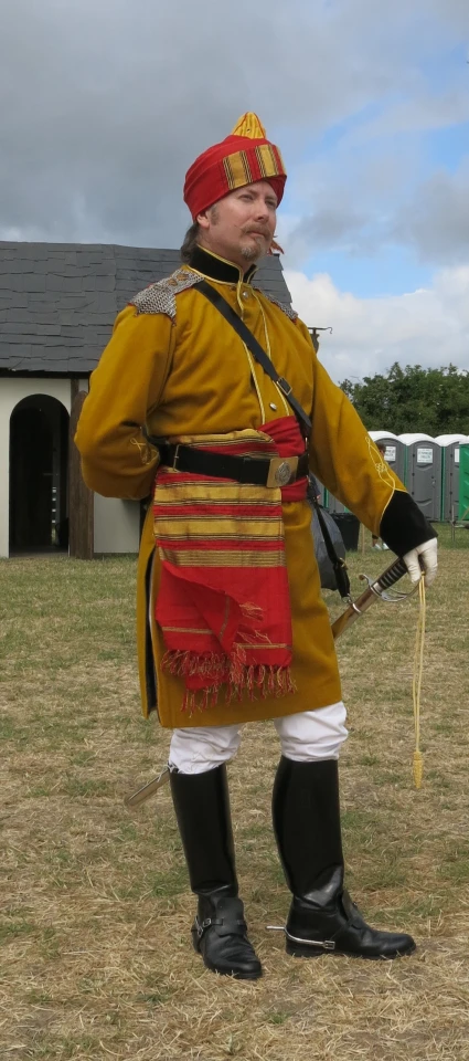 the officer in the old costume stands with his sword