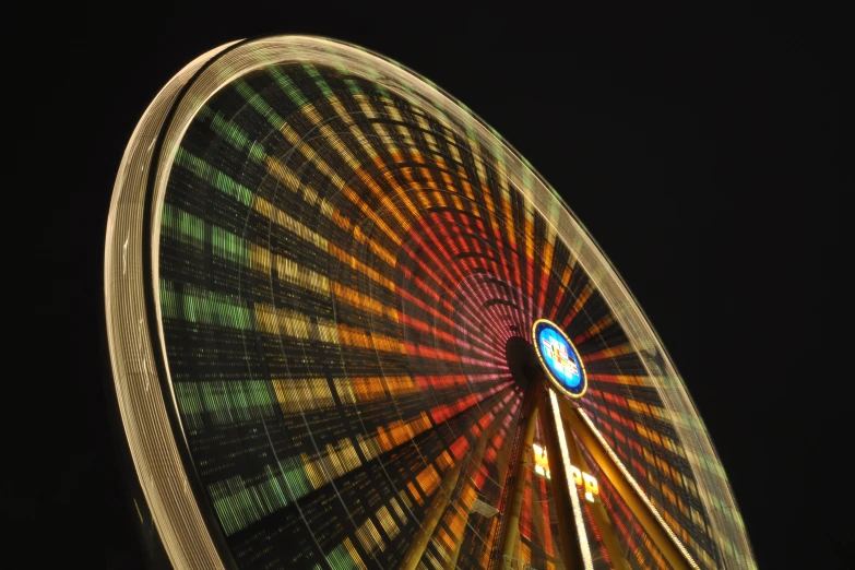 an elaborate wheel is lit by the sun in the night sky