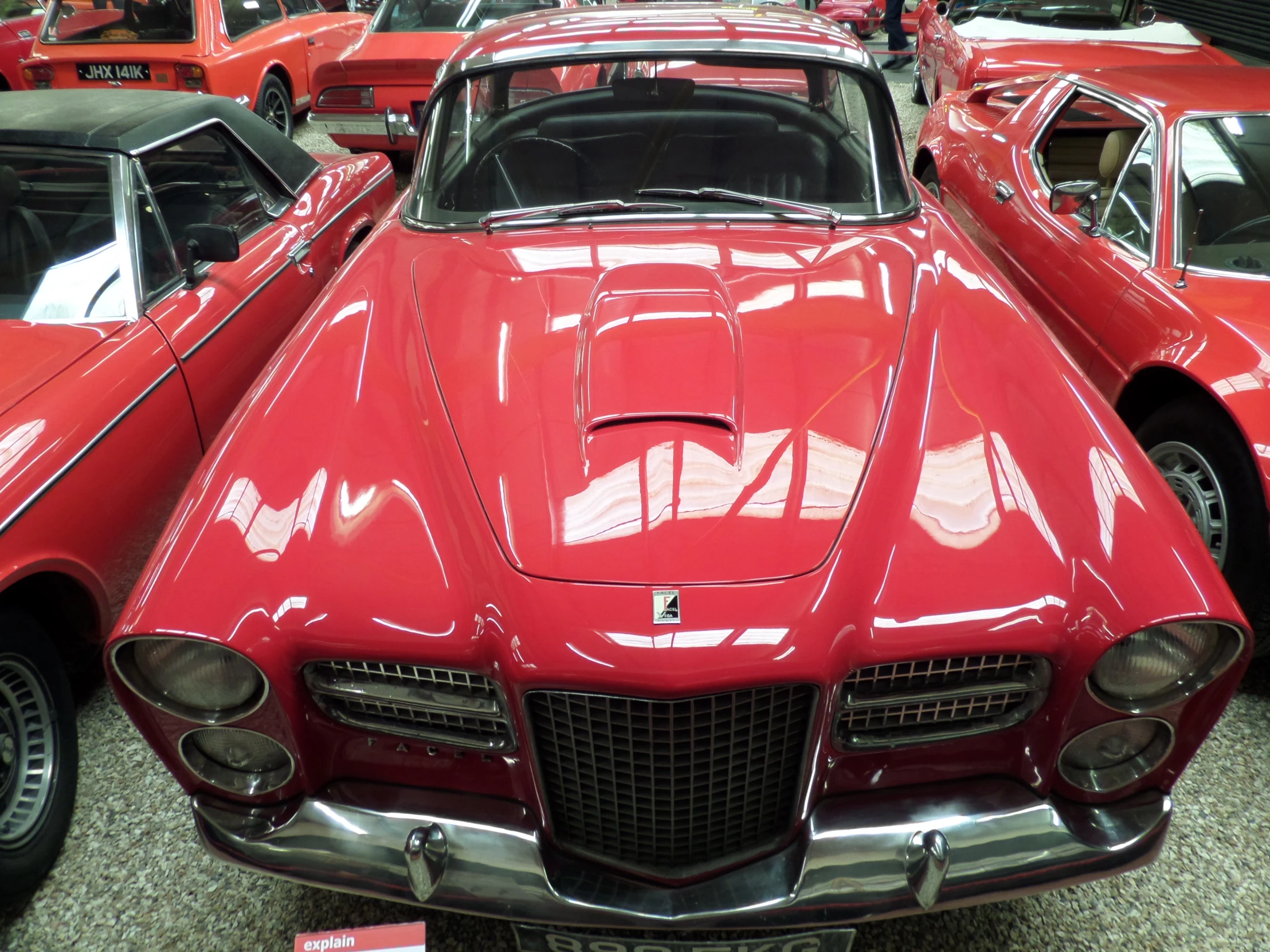 an old classic looking red car in a row