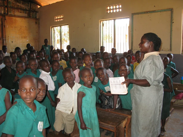 a woman is presenting soing to a schoolboy