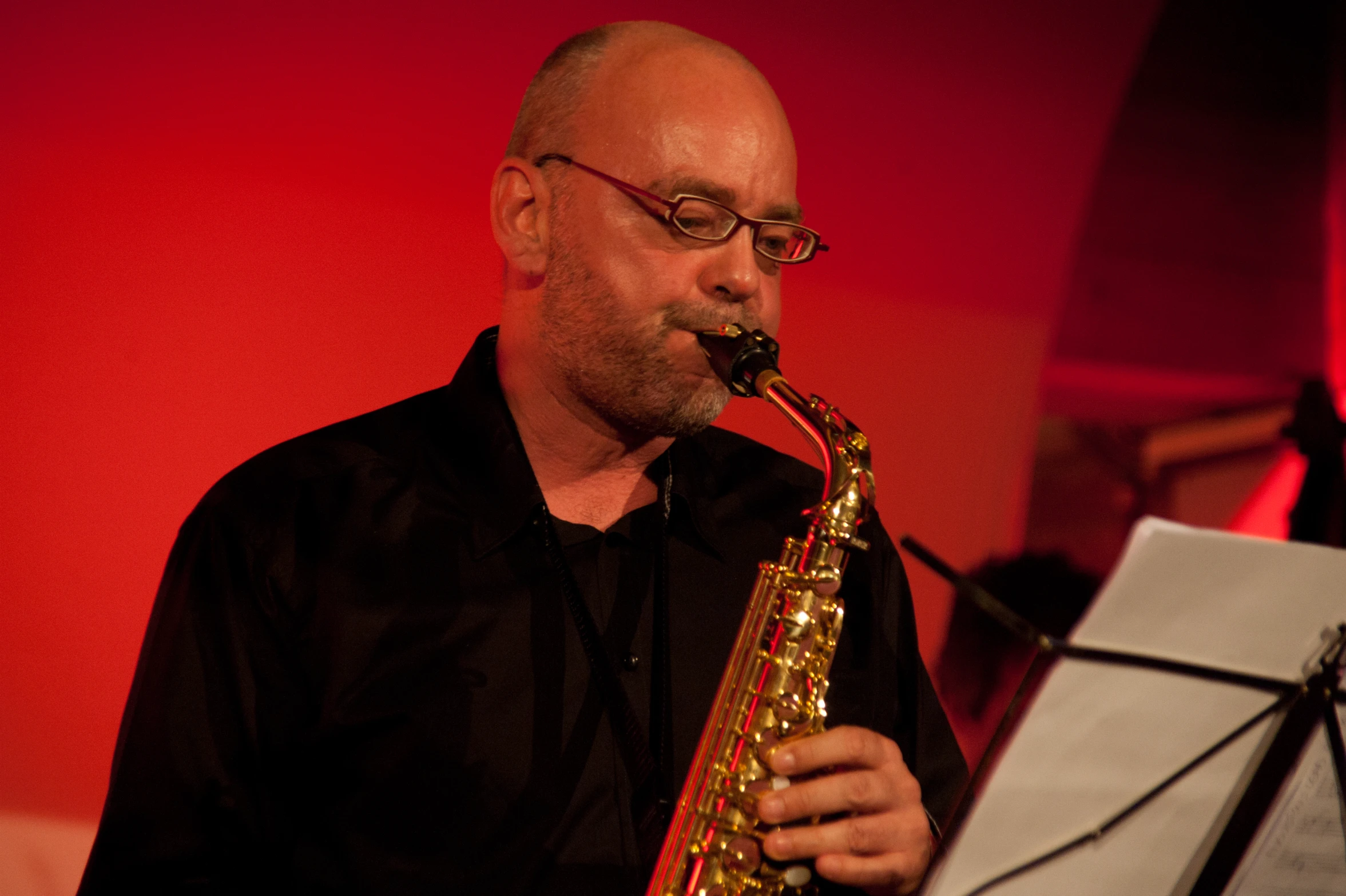 a man in black shirt playing on saxophone