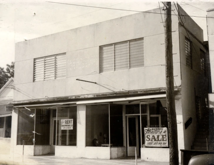 an old po of a building with a sales sign