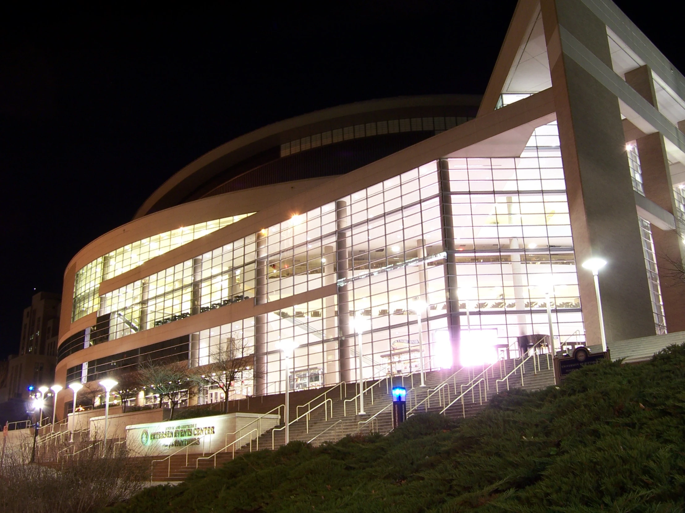 the illuminated stadium building has steps up to it