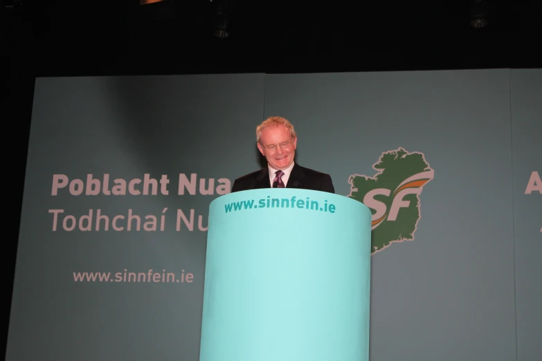 a man is standing at a podium giving a speech