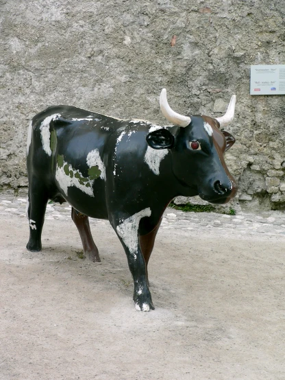 the statue of a cow has black spots and white spots