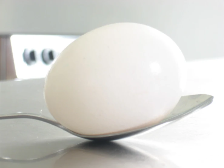 an egg on a spoon that is standing up