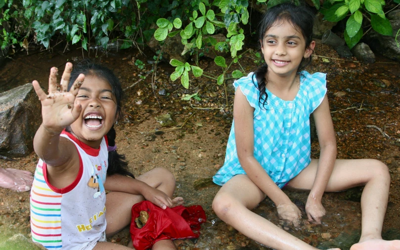 two little girls sitting down on the ground