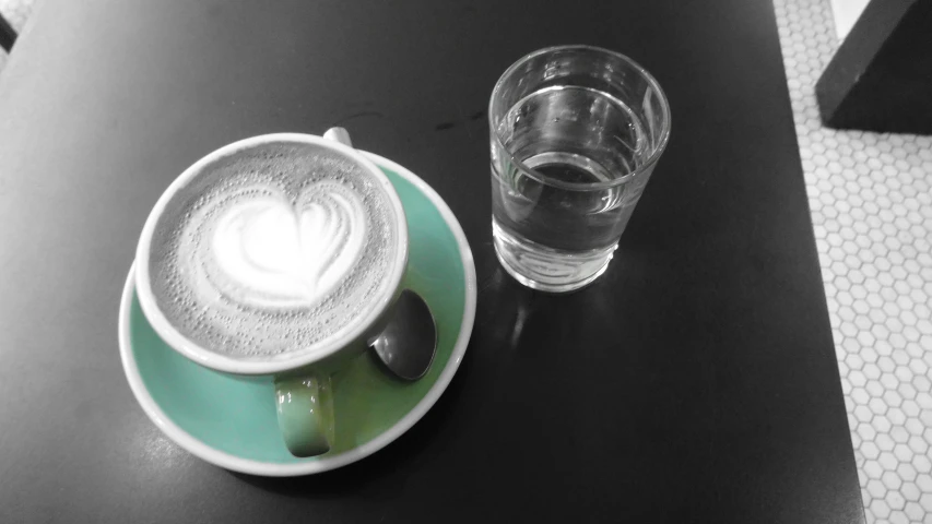 a glass of water and an artisan coffee on the table