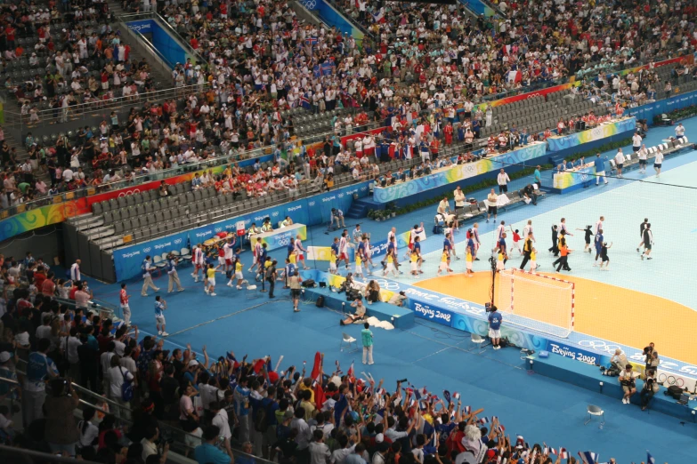 a crowd of people are watching as a volleyball match goes on