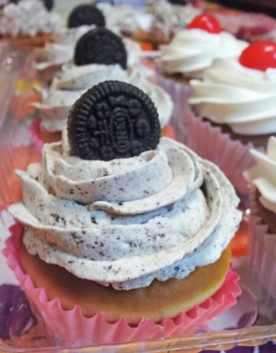 several cupcakes with oreo cookies on them and sprinkles of icing