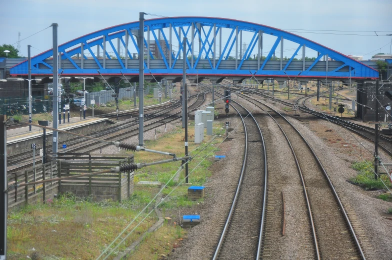 two sets of train tracks with a bridge in the background