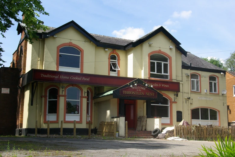 an old building with a small green car in front