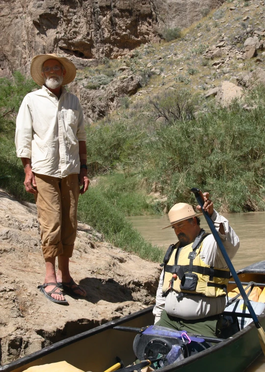 a man is taking a po of a person in a canoe