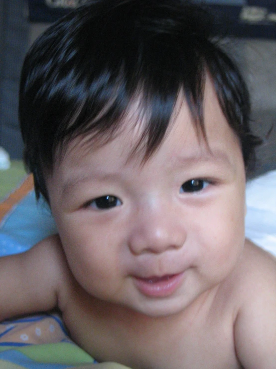 an asian baby smiles into the camera