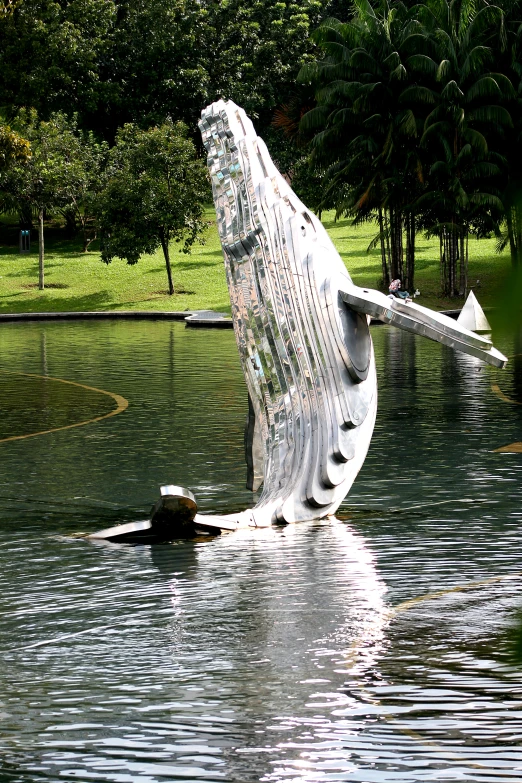 a wooden statue sitting on the side of a lake