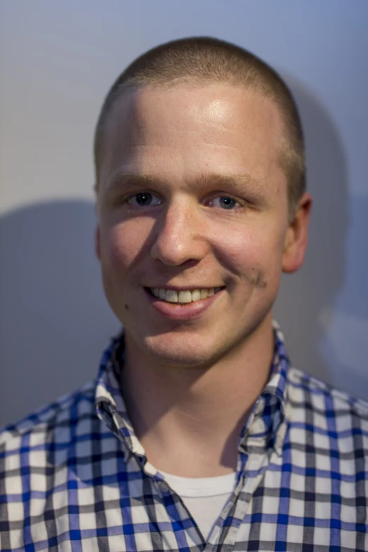 a man standing with his hair tied to the side and smiling