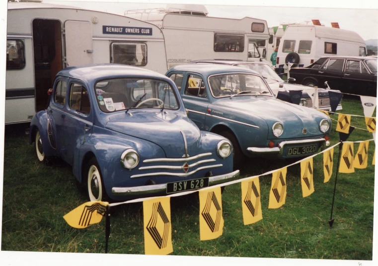 old cars are lined up along a yellow and black road sign