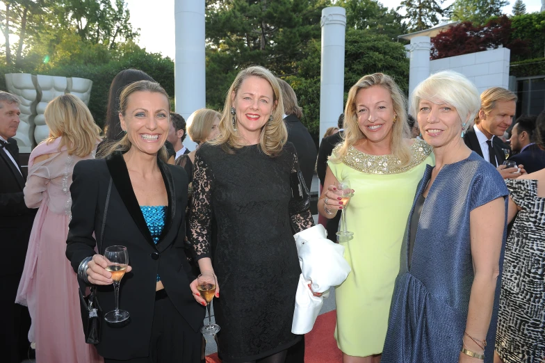 two women standing beside two women holding wine glasses