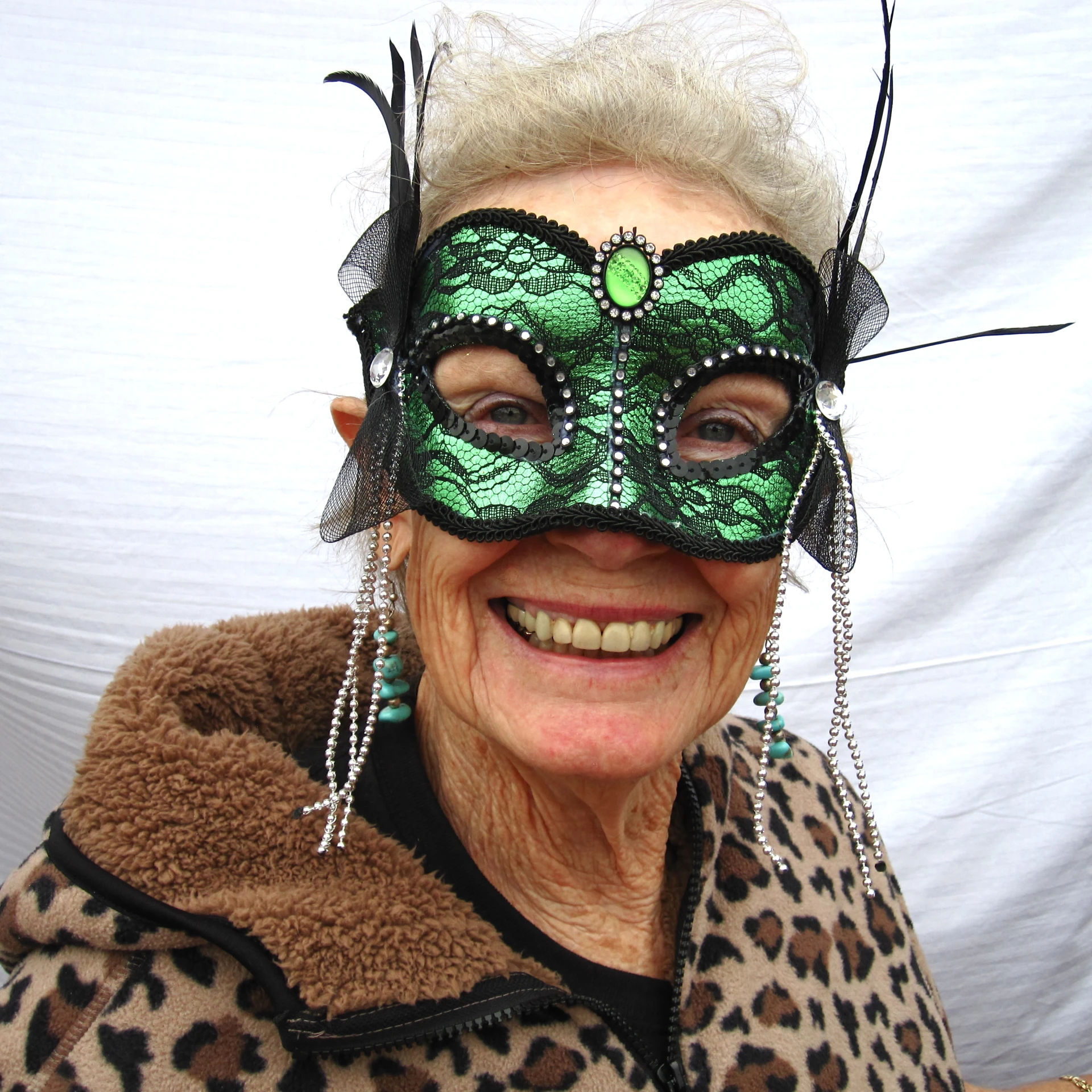 a smiling woman with white hair and green mask