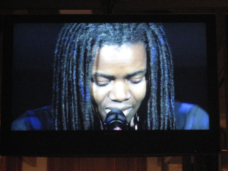 woman with dreadlocks on a large screen television