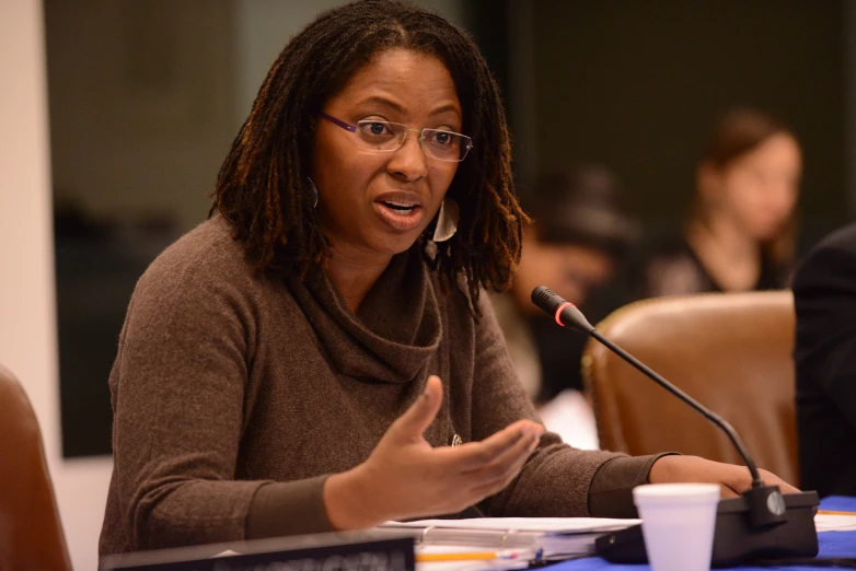 an african american woman sitting in front of a microphone