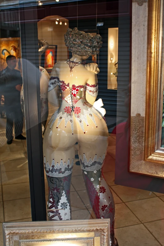 a window display with a figure in the reflection