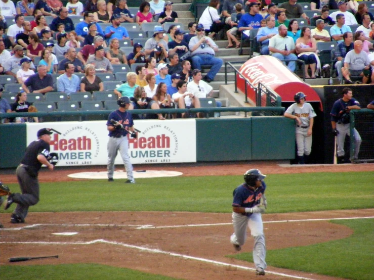 a baseball game in progress with the batter swinging the bat