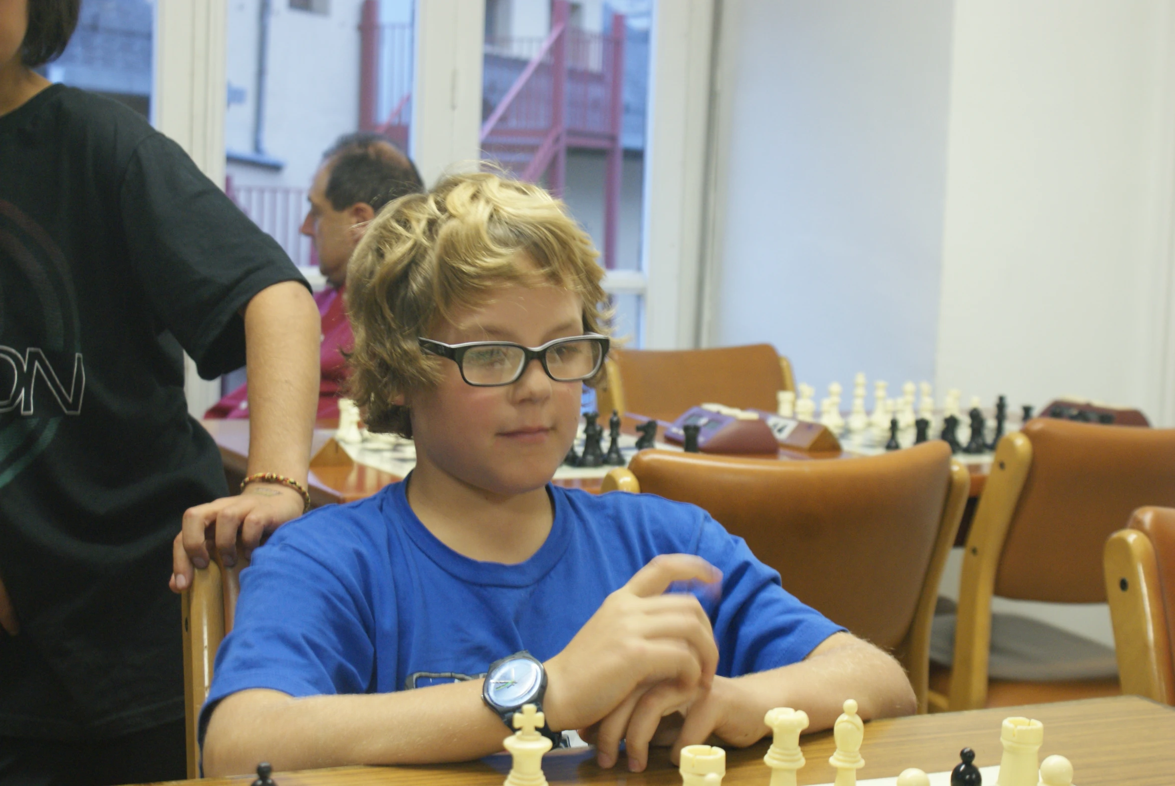 a  sitting at a table playing chess