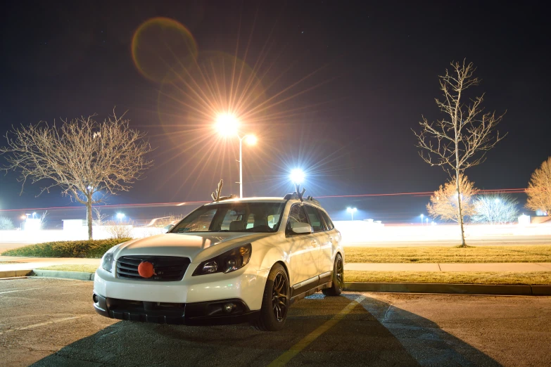 white car on the street at night in an open area