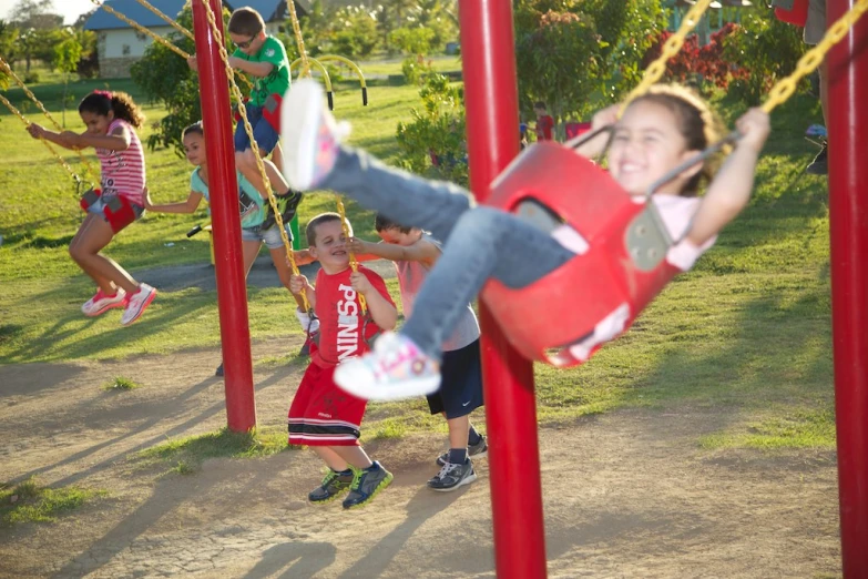 the girl is swinging her leg while a group of other people watch
