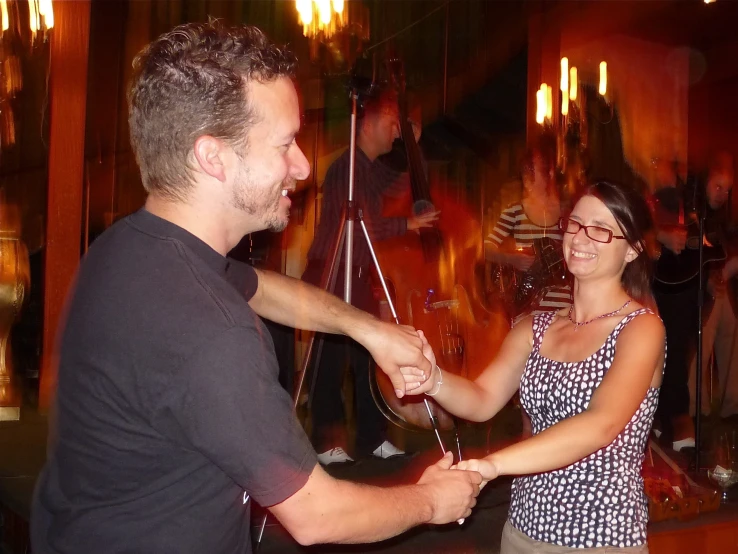 a man in a black shirt is holding a woman's hand