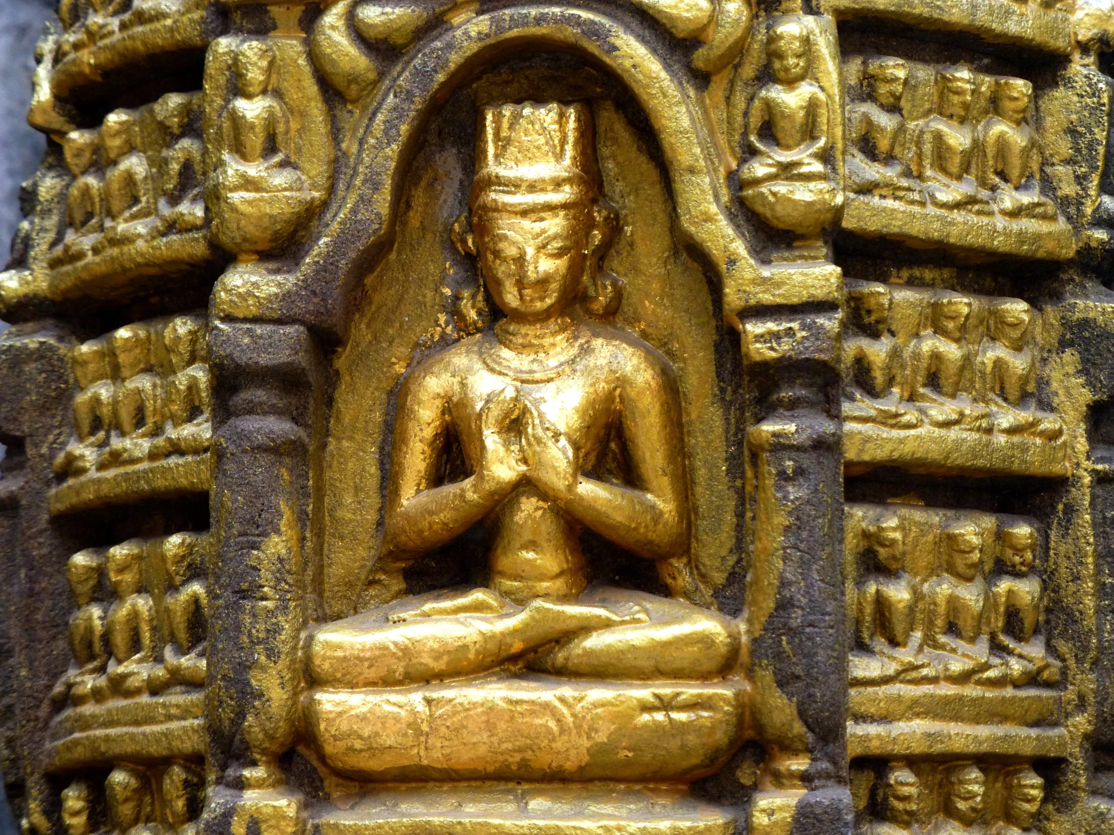 a golden sculpture of buddhas in a temple