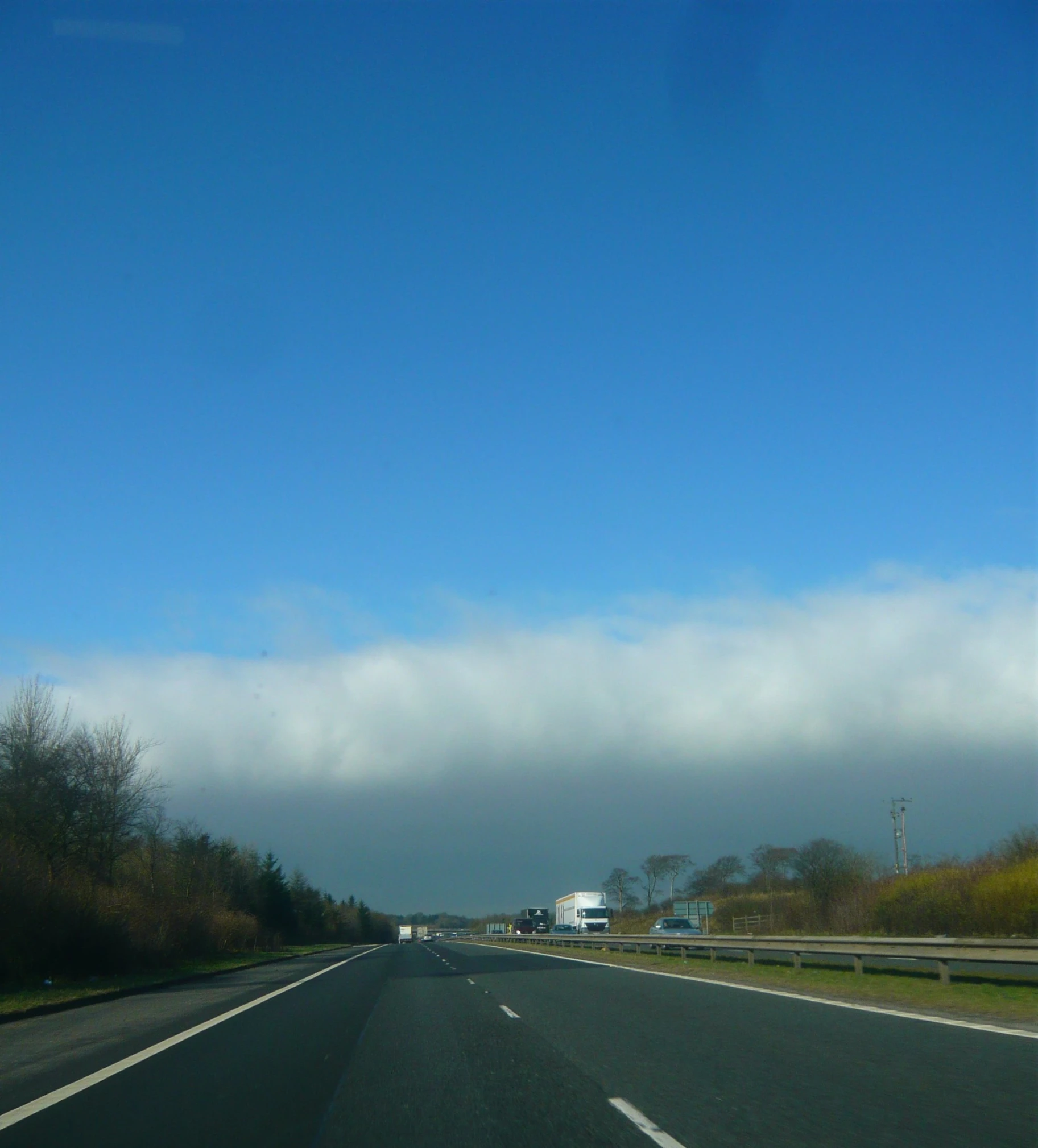 a car riding down the highway with its headlights on