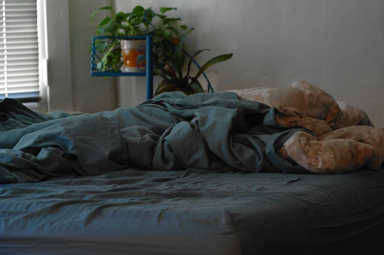 an image of an unmade bed with a blanket on it