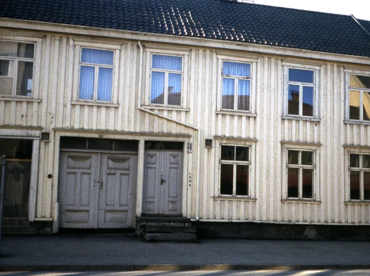 an old, empty house is on the corner of the street