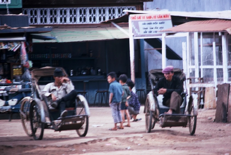 people on small cart pulled by motorcycle pulling small wagon