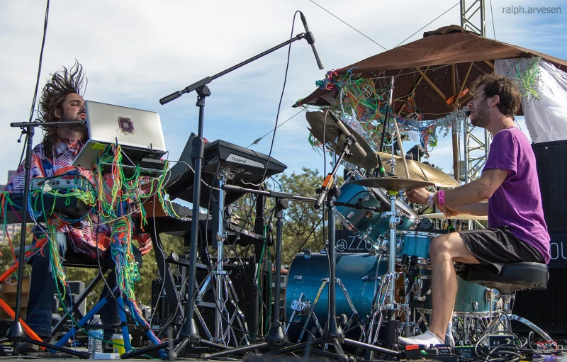 people sitting on the side of a stage with drums