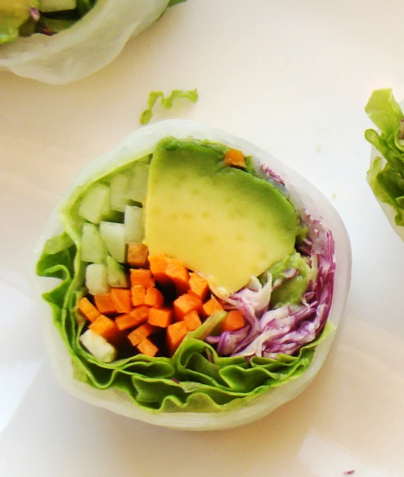 lettuce, carrots, cabbage and avocado are in a salad bowl