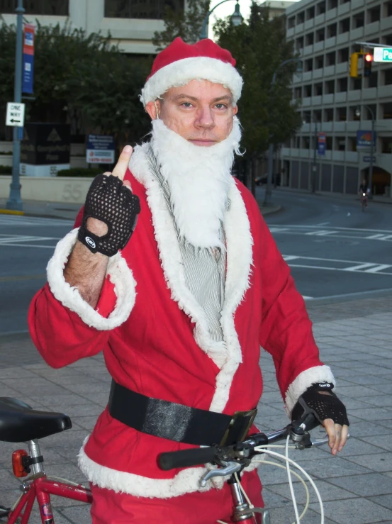 a man dressed as santa claus giving the finger sign