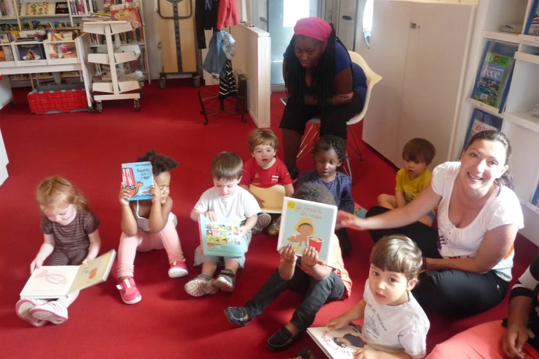 a woman is reading a story book to a group of children