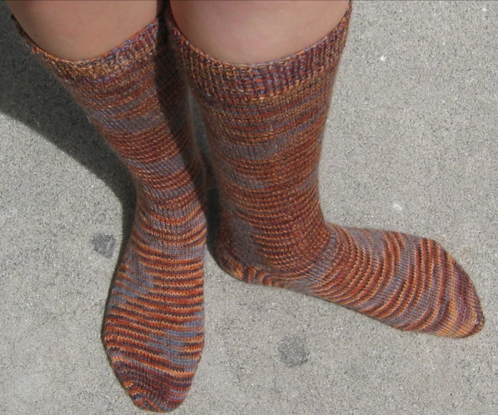 a pair of feet in socks with a dog in the background