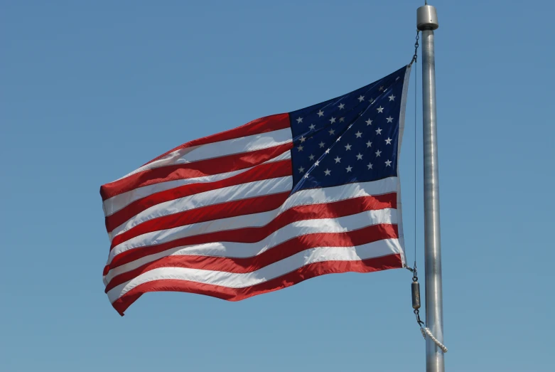 a large american flag flying high into the sky