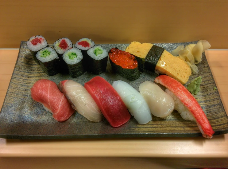 a sushi dish served on a plate with a garnish of vegetables