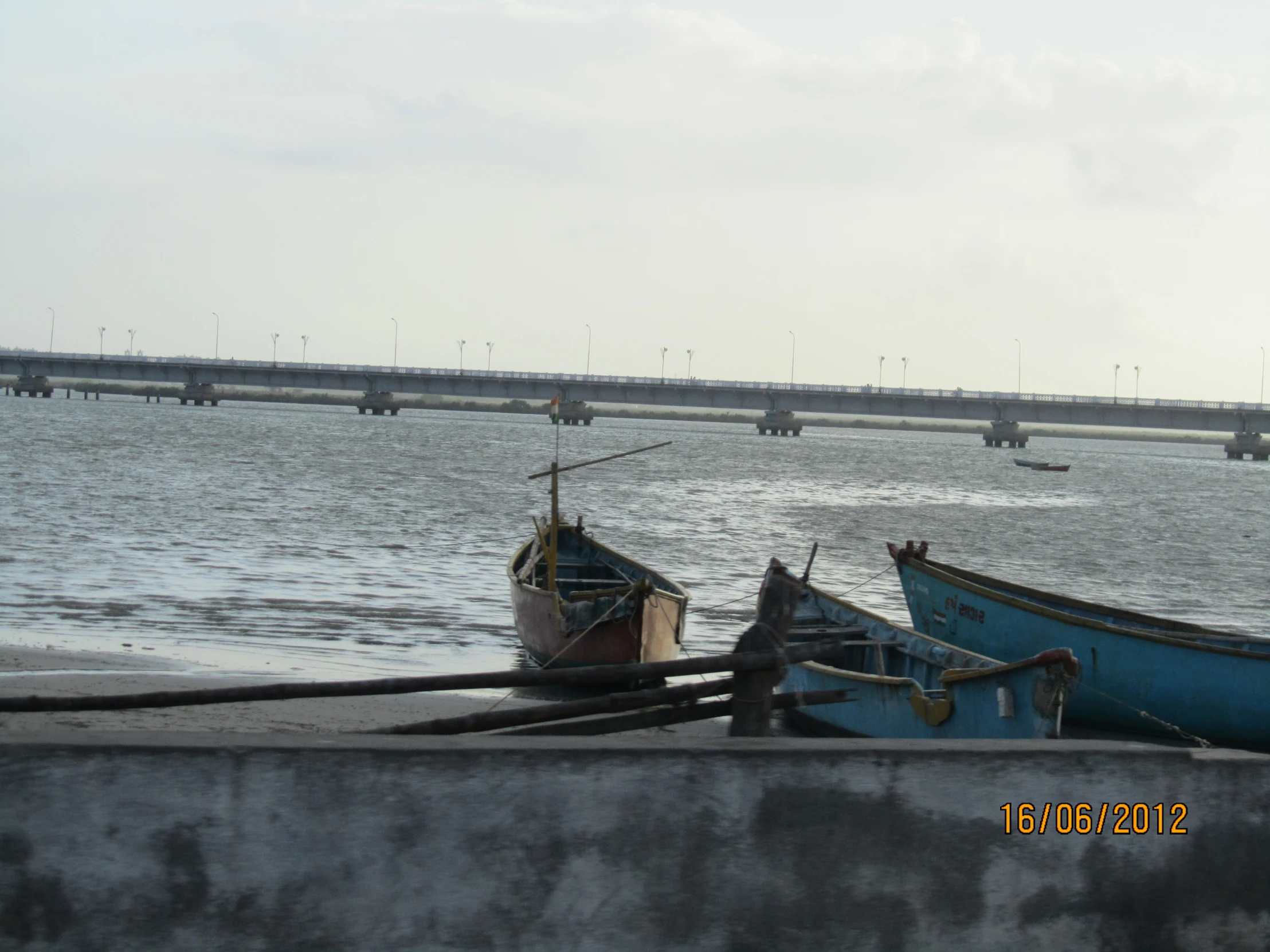 a group of boats sitting on the sand near a body of water