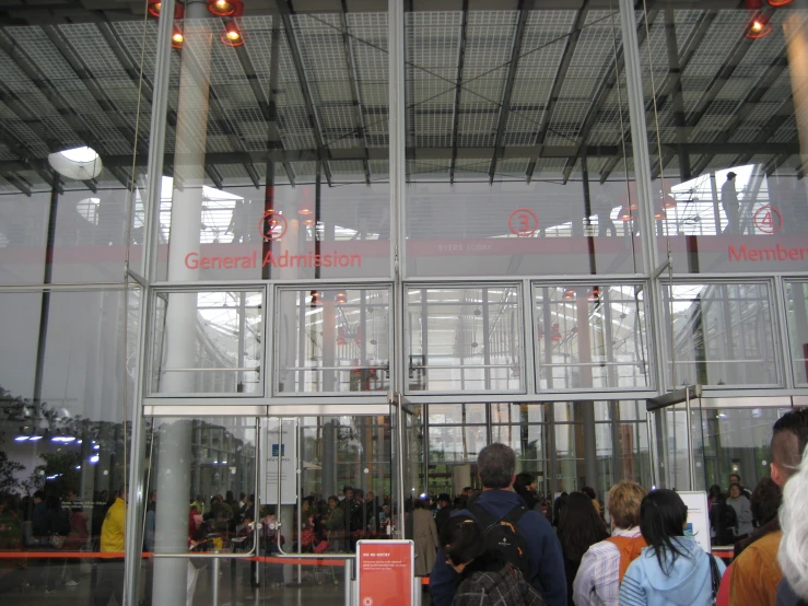 a large group of people waiting in front of a building